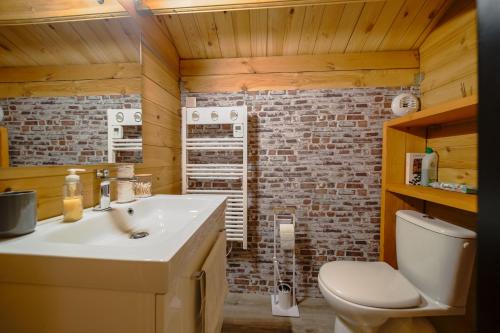 a bathroom with a white sink and a brick wall at Chalet L'Abitiz in Puyvalador