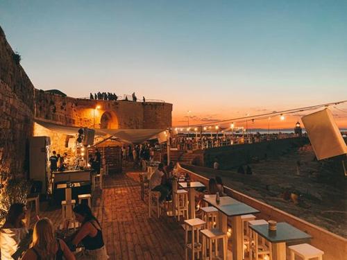 a group of people sitting at tables in a restaurant at Insula Maris in Trani
