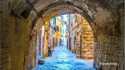 a painting of an alleyway in an old building at Insula Maris in Trani