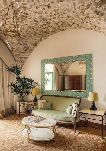 a living room with a couch and a mirror at Caruso, A Belmond Hotel, Amalfi Coast in Ravello