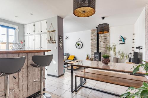 - une cuisine et un salon avec une table et un banc dans l'établissement La Jeannette - maison avec jardin, à Ver-sur-Mer