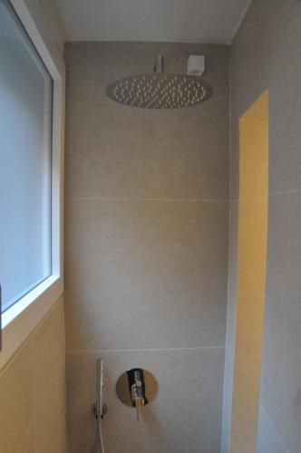a bathroom with a shower with a shower head at Modena Charme Belle Arti in Modena