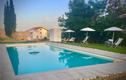 a swimming pool with two umbrellas and two chairs at B&B Prato San Lorenzo in Nocciano