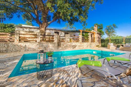 a pool with chairs and a table next to a house at Luxury house Ivan with 4 bedrooms in Divojevići