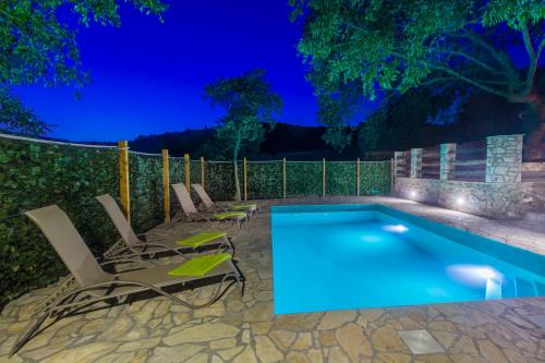 a swimming pool with chairs next to a fence at Luxury house Ivan with 4 bedrooms in Divojevići