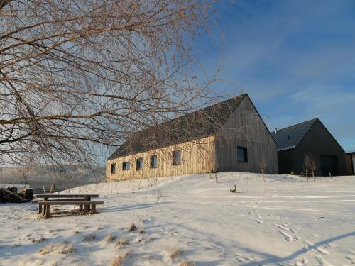 a large barn in the snow with a picnic table at Wzgórze Owiec Sheep Hill in Mostowice