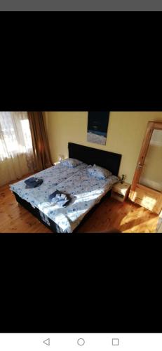 a bed in a room with a bedsheet on it at Къща Томови,стаи за гости in Devin