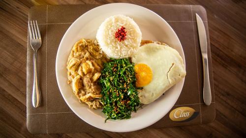 a plate of food with eggs and rice and vegetables at Class Hotel Passos in Passos