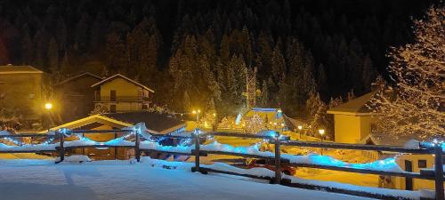 a fence covered in snow at night with lights at Locanda della Luna in Ronco Canavese