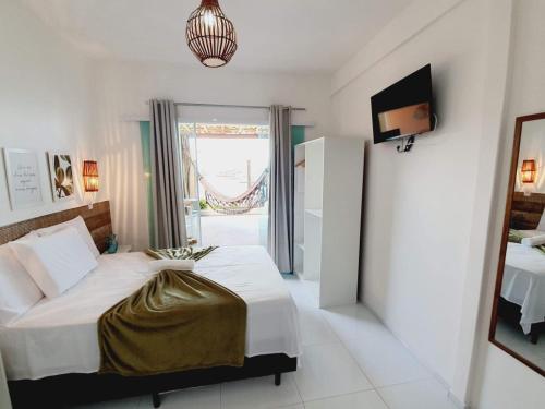 a bedroom with a bed and a television in it at Pousada Mar da Gamboa in Cayru