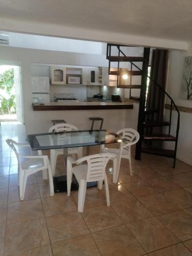a dining room with a glass table and chairs at El Castillo Monte Campana in Puntarenas