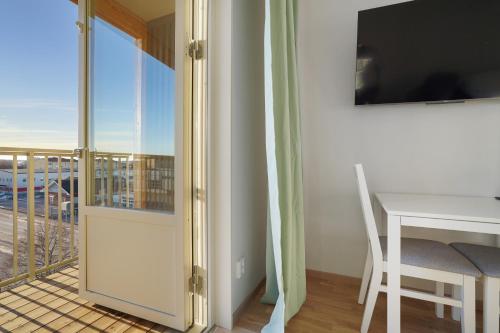 a room with a table and a balcony with a view at Uppsala Hotel Apartments in Uppsala