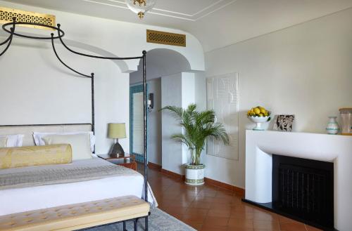 a bedroom with a bed and a fireplace at Caruso, A Belmond Hotel, Amalfi Coast in Ravello