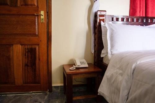 Un pat sau paturi într-o cameră la Turbine Ngong Hotel