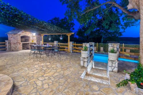 a patio with a table and chairs at night at Luxury house Ivan with 4 bedrooms in Divojevići