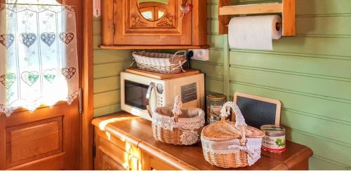 une cuisine avec un micro-ondes et des paniers sur un comptoir dans l'établissement Studio cosy à Bussac-Forêt avec piscine partagée, 15m², à Bussac-Forêt
