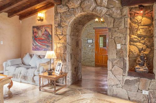 a living room with a stone wall at Aldebaran Hotel & Spa in San Carlos de Bariloche