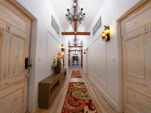 a hallway with a rug on the floor and a chandelier at Open Door Loft in Ponta Delgada