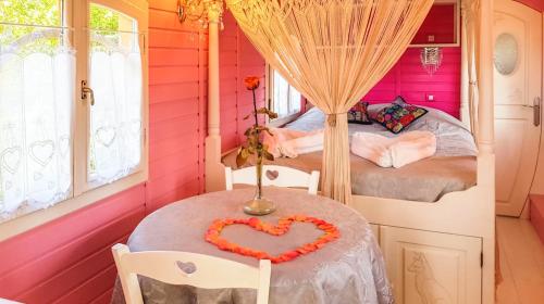 - une chambre avec 2 lits et une table avec un cœur fait dans l'établissement Bungalow cosy à Bussac-Forêt avec piscine partagée 15 m², à Bussac-Forêt