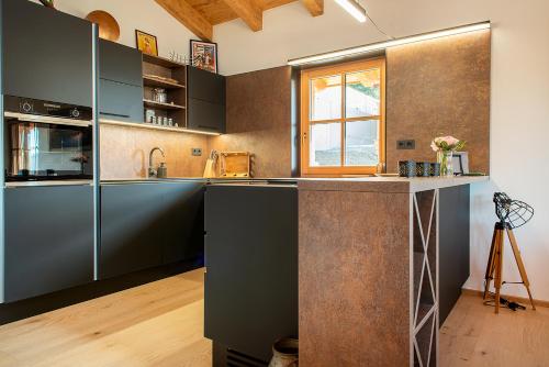a kitchen with gray cabinets and a large island at Skyberg Chalet in Mühlbach am Hochkönig