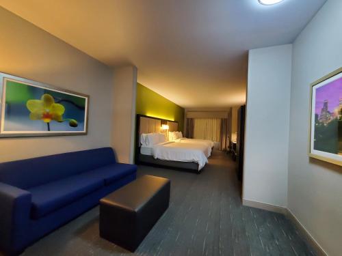Holiday Inn Express Pearland, an IHG Hotel في بيرلاند: غرفة في الفندق مع أريكة وسرير