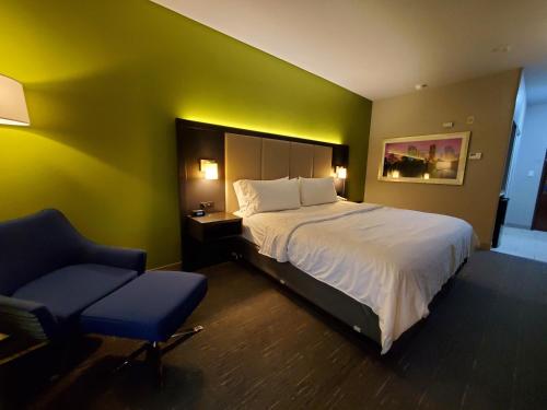 a hotel room with a bed and a chair at Holiday Inn Express Pearland by IHG in Pearland