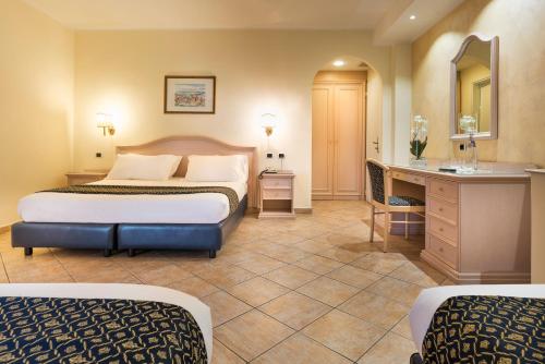 a hotel room with a bed and a desk at Sant Alphio Garden Hotel & SPA in Giardini Naxos