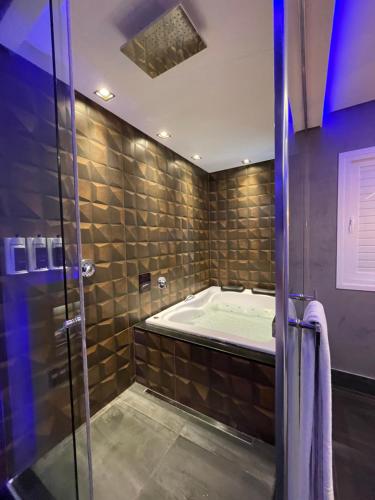 uma casa de banho com um chuveiro e uma banheira em Fantasy Motel em Salvador