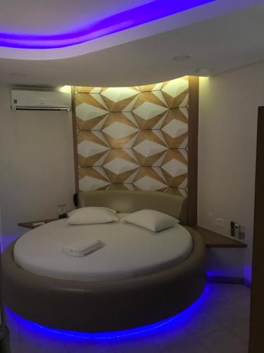 a bedroom with a bed with a purple lighting at Fantasy Motel in Salvador