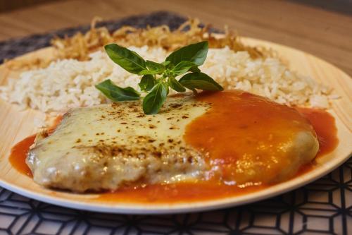 a plate of food with meat and rice on a table at Fantasy Motel in Salvador