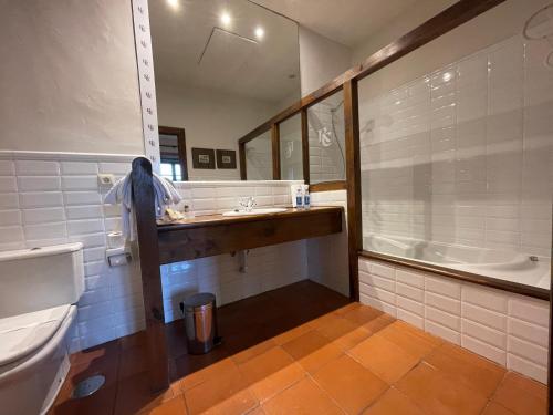 a bathroom with a toilet and a sink and a tub at Rectoral de Cines in Oza dos Ríos