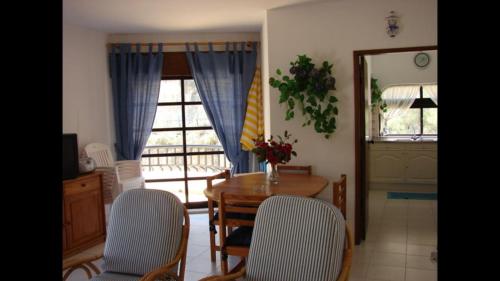 a dining room with a table and chairs and a window at Apartamento na praia do Carvoeiro in Praia do Carvoeiro