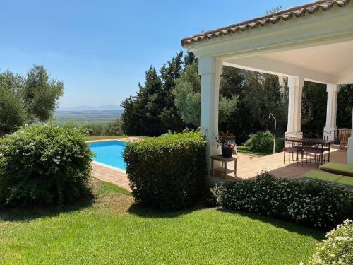 ein Haus mit einer Terrasse und einem Pool in der Unterkunft Charming 2 bedroom villa on Fairplay Golf course in Benalup Casas Viejas