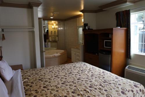 1 dormitorio con 1 cama y baño con bañera en Lambert Inn, en Whittier