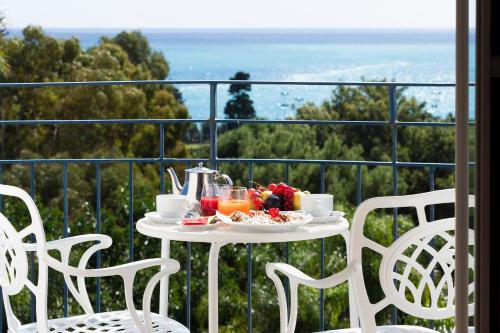 a table with a tray of fruit on a balcony at Sant Alphio Garden Hotel & SPA in Giardini Naxos