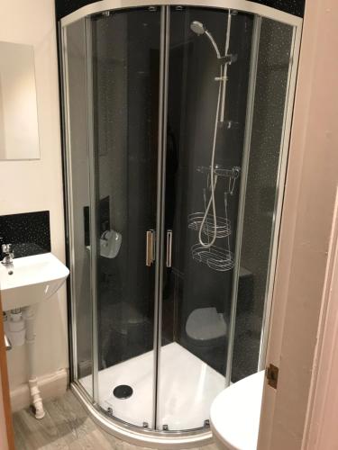 a shower with a glass door in a bathroom at The Golden Lion Hotel in Middlewich