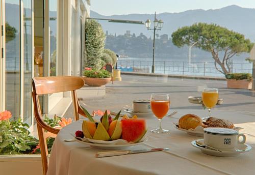 a table with fruit and drinks on a table on a balcony at Best Western Regina Elena in Santa Margherita Ligure