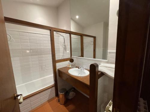 a bathroom with a sink and a mirror and a tub at Rectoral de Cines in Oza dos Ríos