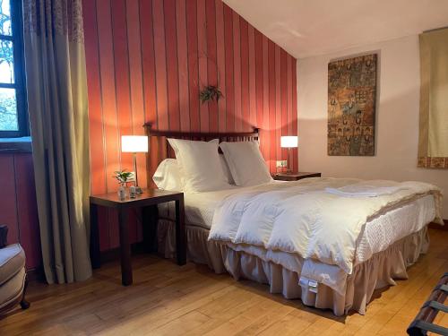 a bedroom with a bed and two tables with lamps at Rectoral de Cines in Oza dos Ríos