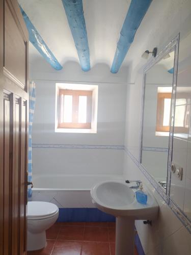 un bagno con un water, un lavandino e uno specchio di Casa Rural El Cortijo Nuevo, en El Cerezo a El Cerezo