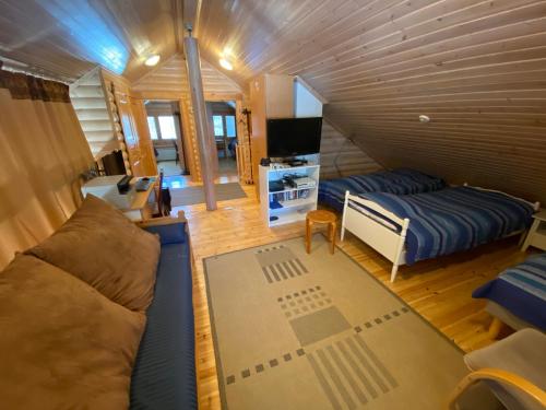 a room with a couch and a bed and a tv at Luoston Väärtin Kammi in Luosto