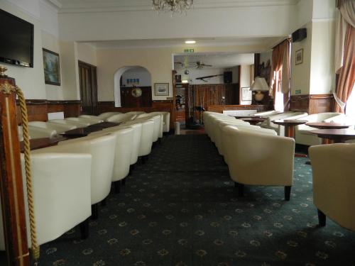 a large room with a long row of tables and chairs at St George Hotel Great Yarmouth in Great Yarmouth