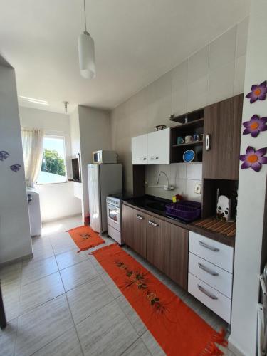 a kitchen with a refrigerator and a counter top at Apto Solar da Praia in Piçarras