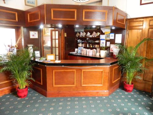 a counter in a store with two potted plants at St George Hotel Great Yarmouth in Great Yarmouth