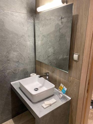 a bathroom with a white sink and a mirror at 11 Luxury Apartments in Metsovo