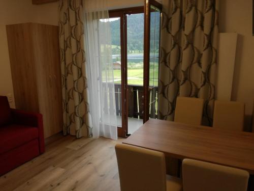 a dining room with a table and chairs and a window at Haus Alpenfriede in Weissensee