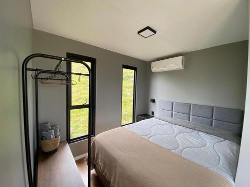 um quarto com uma cama grande e um espelho em Leão da Montanha - Hospedaria Rural em Cambará