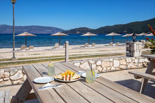 a wooden table with a plate of food on the beach at Sami Beach Hotel in Sami