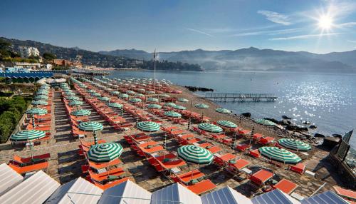 a group of umbrellas and chairs on a beach at Best Western Regina Elena in Santa Margherita Ligure