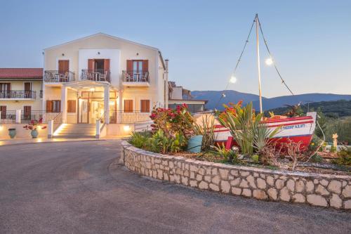 a house with a boat in front of it at Sami Beach Hotel in Sami